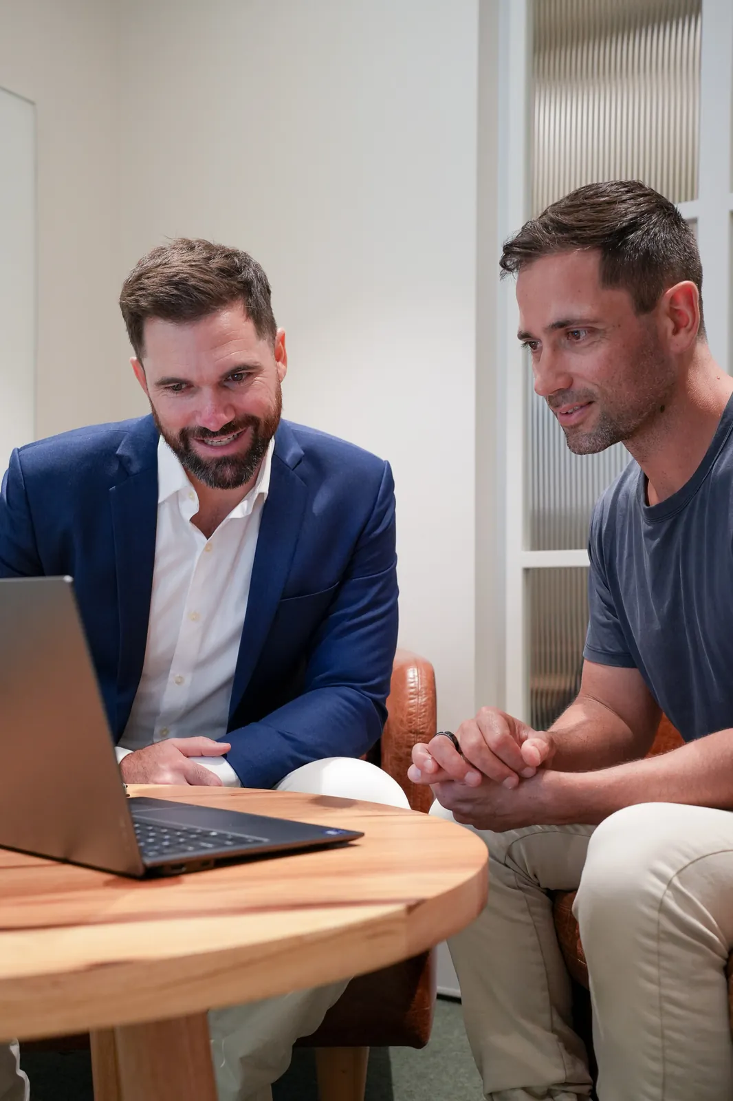 Jason and a client looking at loan options on a laptop