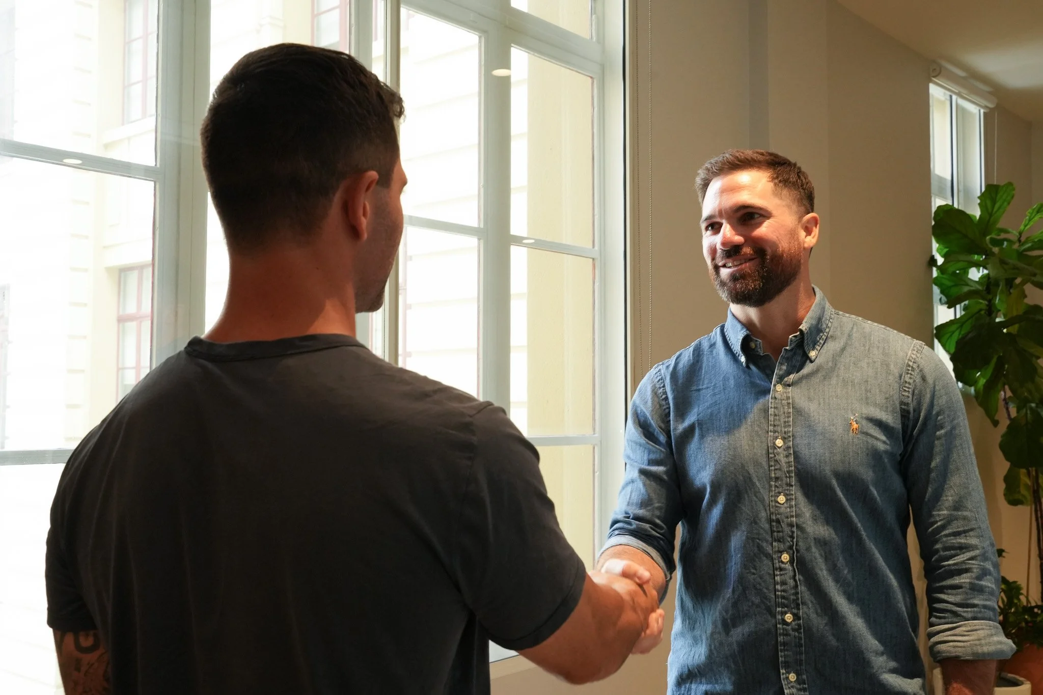 Jason shaking hands with a client in a sunlit office