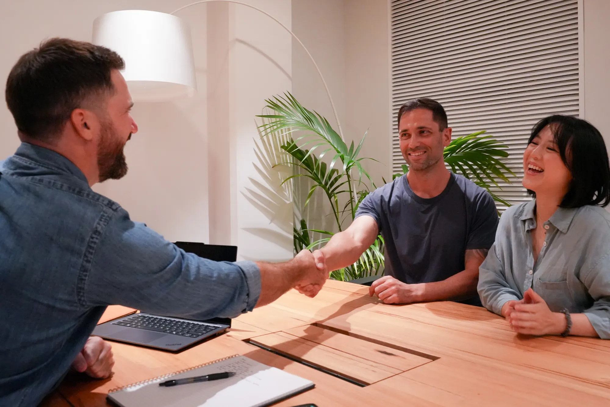 Jason shaking hands with clients across a meeting table